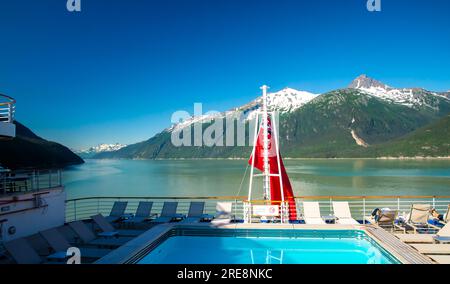 Sul retro della nave da crociera, ammira lo splendido paesaggio del Parco nazionale del ghiacciaio dell'Alaska, con acqua blu e montagne innevate Foto Stock