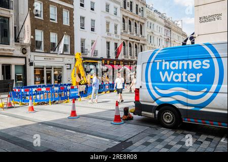 Londra, Regno Unito. 26 luglio 2023. Stiamo riparando tubi dice il cartello sulla recinzione intorno a un buco scavato da Thames Water in Old Bond Street. La mancanza di attività è una metafora dei problemi dell'azienda e dei lenti progressi nella riparazione delle perdite. Crediti: Guy Bell/Alamy Live News Foto Stock