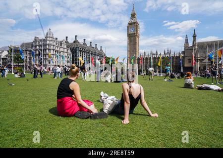 Londra Regno Unito. 26 luglio 2023 i turisti si rilassano al sole in Piazza del Parlamento in una giornata calda nella capitale prima che piogge pesanti a Londra e nel sud-est di giovedì. Credit amer ghazzal/Alamy Live News Foto Stock