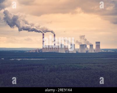 Vista aerea della centrale elettrica, fumo dai camini e miniera di carbone a cielo aperto a Belchatow sotto un cielo nuvoloso, Polonia Foto Stock