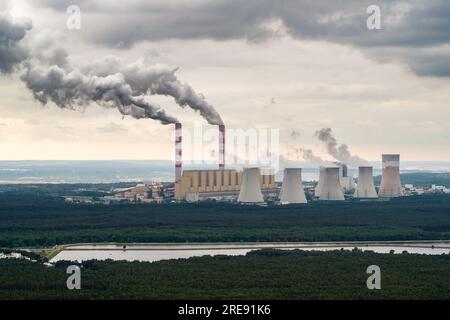 Vista aerea della centrale elettrica, fumo dai camini e miniera di carbone a cielo aperto a Belchatow sotto un cielo nuvoloso, Polonia Foto Stock