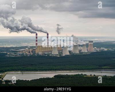 Vista aerea della centrale elettrica, fumo dai camini e miniera di carbone a cielo aperto a Belchatow sotto un cielo nuvoloso, Polonia Foto Stock