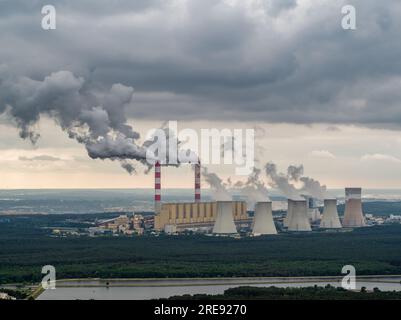 Vista aerea della centrale elettrica, fumo dai camini e miniera di carbone a cielo aperto a Belchatow sotto un cielo nuvoloso, Polonia Foto Stock