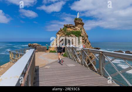 Biarritz, Francia, 03 luglio 2023: Turisti al rocher de la Vierge (roccia vergine di maria) a Biarritz. Aquitania, Paesi Baschi, Francia. Foto Stock