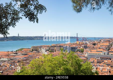 Tetti arancioni con Ponte 25 de Abril e Santuario de Cristo Rei sullo sfondo, situato a Lisbona, Portogallo Foto Stock