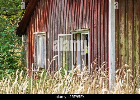 Vecchio cottage in cattive condizioni con finestre aperte Foto Stock