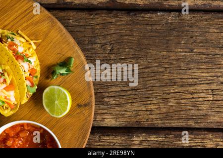 Direttamente sopra lo shot di tacos con limone, coriandolo e sugo di carne nel recipiente su tavola Foto Stock