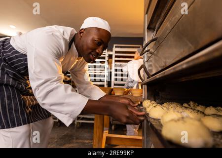 Fornai sempre con grembiuli in cucina e panini da forno Foto Stock