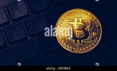 Bitcoin sulla tastiera compuer in background, simbolo di elettronici di denaro virtuale e data mining cryptocurrency concetto. Coin moneta crypto bitcoin giace sul Foto Stock