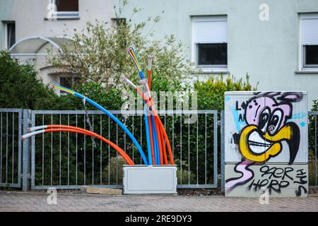 Zwenkau, Germania. 26 luglio 2023. I cavi in fibra ottica sporgono dalla base di un quadro di controllo. L'operatore di rete in fibra ottica della Germania orientale Envia Tel vuole collegare circa 80.000 famiglie a Internet ad alta velocità nei prossimi anni. Lo scopo è raggiungere larghezze di banda fino a 1 gigabit al secondo. Per questo sono previsti investimenti superiori a 350 milioni di euro entro il 2026. Crediti: Jan Woitas/dpa/Alamy Live News Foto Stock