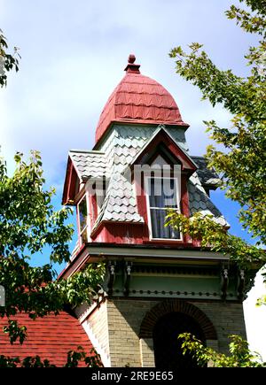 La splendida casa vittoriana Queen Ann ha una torre quadrata con una cupola a quattro lati e quattro dormitori. Le tegole di legno sono sbiadite di verde pastello. Foto Stock