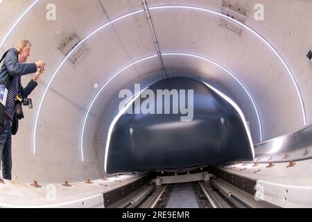 Ottobrunn, Germania. 26 luglio 2023. Il tubo del binario di prova Hyperloop con la sua cabina di trasporto è aperto per la visione prima che inizi l'apertura. Il nuovo tracciato di prova Hyperloop presso l'Università tecnica di Monaco (TUM) comprende un tubo del vuoto lungo 24 metri in calcestruzzo e un veicolo passeggeri di dimensioni normali - è il primo in Europa ad essere completamente certificato per il funzionamento dei passeggeri, secondo TUM. Crediti: Peter Kneffel/dpa/Alamy Live News Foto Stock