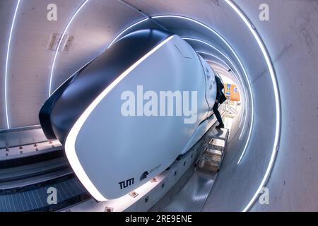 Ottobrunn, Germania. 26 luglio 2023. Il tubo del binario di prova Hyperloop con la sua cabina di trasporto è aperto per la visione prima che inizi l'apertura. Il nuovo tracciato di prova Hyperloop presso l'Università tecnica di Monaco (TUM) comprende un tubo del vuoto lungo 24 metri in calcestruzzo e un veicolo passeggeri di dimensioni normali - è il primo in Europa ad essere completamente certificato per il funzionamento dei passeggeri, secondo TUM. Crediti: Peter Kneffel/dpa/Alamy Live News Foto Stock
