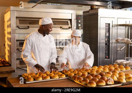 Prepara i panettieri con grembiuli nella cucina dei prodotti da forno e contano panini freschi Foto Stock