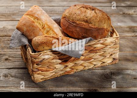 Varietà di pane assortite in un incantevole cestino, pronto per essere gustato Foto Stock