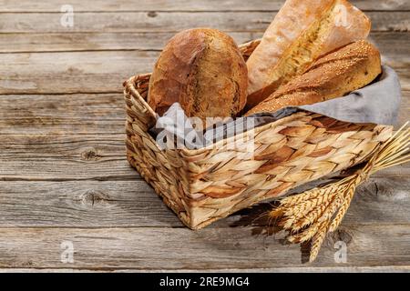 Varietà di pane assortite in un incantevole cestino, pronto per essere gustato Foto Stock