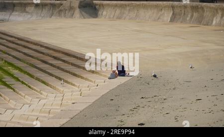 Porthcawl, Bridgend, Galles - 19 giugno 2023: Le nuove difese marittime in cemento sulla spianata di Porthcawl offrono un enorme spazio per attività e relax Foto Stock