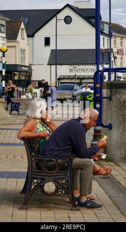 Porthcawl, Bridgend, Galles - 19 giugno 2023: Gli anziani della città si incontrano sul lungomare e chiacchierano in una giornata di sole. Foto Stock