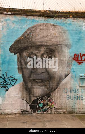 Ritratto del famoso residente nella zona est di Londra Charlie Burns su un muro di mattoni in Bacon Street, Londra, Inghilterra Foto Stock