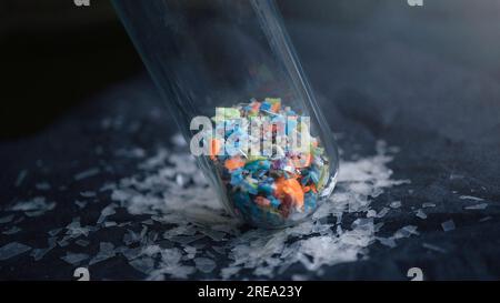 Foto macro di una provetta piena di microplastiche raccolte dalla spiaggia. Concetto di inquinamento idrico e gestione dei rifiuti industriali. Foto Stock