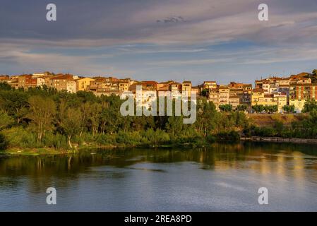 Villaggio di Flix sulle rive del fiume Ebro, visto dalla diga artificiale di Flix al tramonto (Ribera d'Ebre, Tarragona, Catalogna, Spagna) Foto Stock