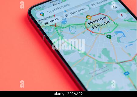 New York, USA - 21 luglio 2023: Distribuzione del traffico automobilistico di Mosca su google Maps su uno schermo dello smartphone vista ravvicinata con sfondo rosso Foto Stock