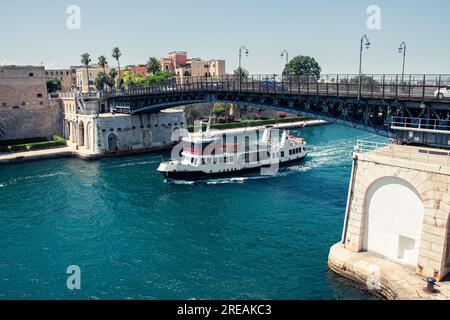 Barca che passa sotto un ponte, Ponte Girevole, a Taranto, Italia. Foto Stock