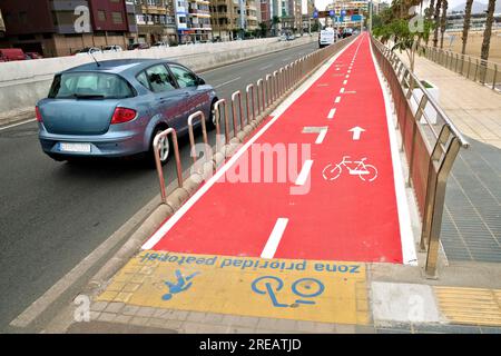 Piste ciclabili di colore rosso brillante chiaramente contrassegnate con il simbolo della bicicletta sullo stencil. Foto Stock