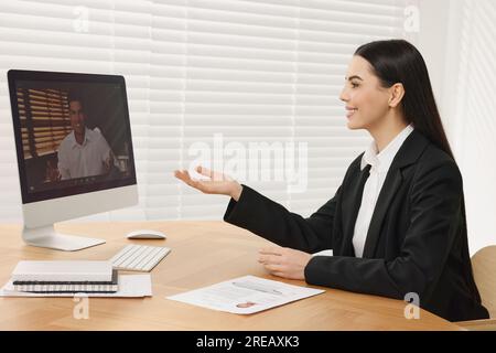 Responsabile delle risorse umane che conduce colloqui di lavoro online tramite video chat sul computer Foto Stock