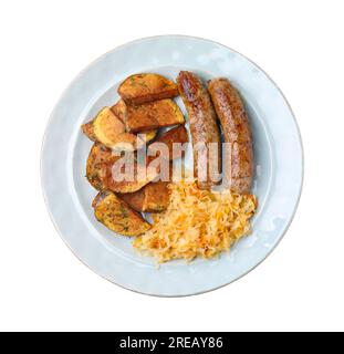 Piatto con crauti, salsicce e patate isolate su bianco, vista dall'alto Foto Stock