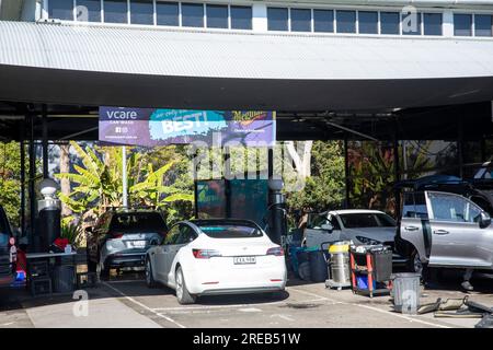 Attività di autolavaggio a mano a Sydney, Australia, una Tesla modello 3 attende di essere lavata e rialzata, Australia Foto Stock