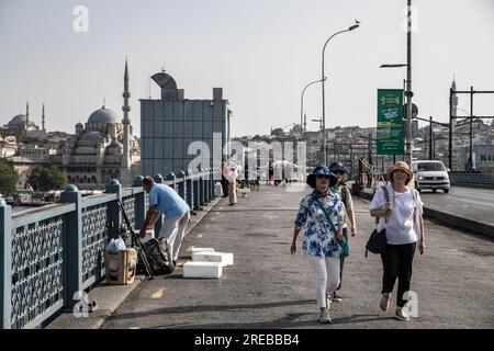 Istanbul, Turchia. 26 luglio 2023. I turisti sono stati visti passare dai pescatori sul ponte di Galata durante il clima caldo. Mentre l'onda di calore mostra l'effetto a Istanbul, la temperatura percepita ha raggiunto i 40 gradi, mentre i termometri hanno mostrato 37 gradi. Credito: SOPA Images Limited/Alamy Live News Foto Stock