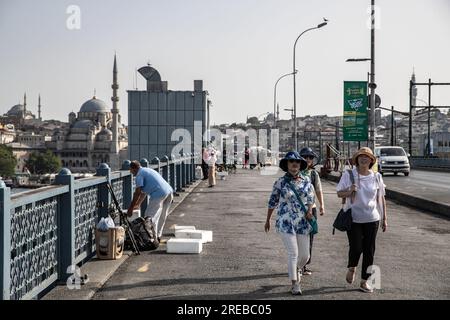 Istanbul, Turchia. 26 luglio 2023. I turisti sono stati visti passare dai pescatori sul ponte di Galata durante il clima caldo. Mentre l'onda di calore mostra l'effetto a Istanbul, la temperatura percepita ha raggiunto i 40 gradi, mentre i termometri hanno mostrato 37 gradi. (Foto di Onur Dogman/SOPA Images/Sipa USA) credito: SIPA USA/Alamy Live News Foto Stock