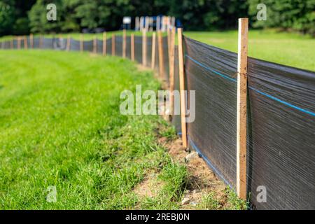 Tessuto Silt Fence con pali in legno installati prima dell'inizio della costruzione. Foto Stock