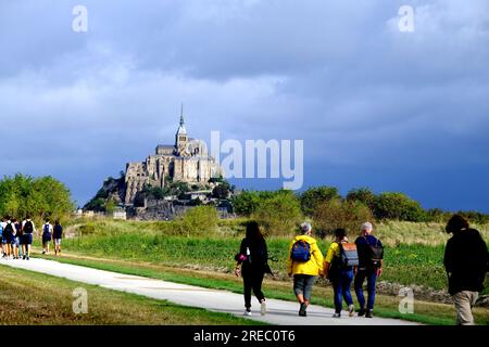 Turisti che camminano verso Mont Saint Michel in Normandia Francia Foto Stock