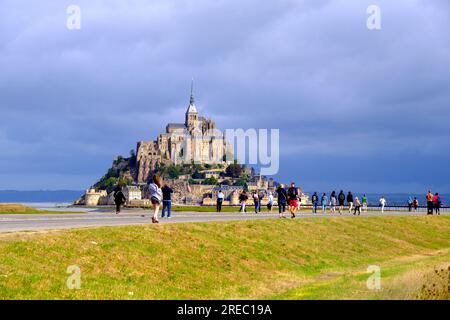 Turisti che camminano verso Mont Saint Michel in Normandia Francia Foto Stock