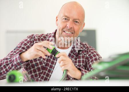 man collega tubi flessibili Foto Stock