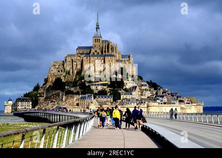 Turisti che camminano verso Mont Saint Michel in Normandia Francia Foto Stock