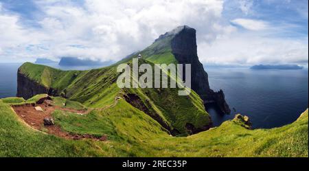 Kallur faro sulle verdi colline di Kalsoy isola, isole Faerøer, Danimarca. Fotografia di paesaggi Foto Stock