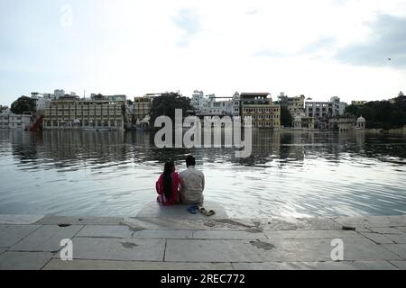 Jodhpur, India. 26 luglio 2023. Una coppia si siede ai ghat del lago Pichola a Udaipur, Rajasthan, India, mercoledì 26 luglio 2023. Udaipur nel Rajasthan è anche chiamata città dei laghi. Foto di Anshuman Akash/ABACAPRESS.COM credito: Abaca Press/Alamy Live News Foto Stock