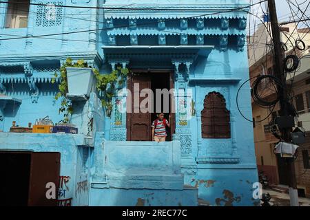 Jodhpur, India. 25 luglio 2023. Un ragazzo si trova alla porta di una casa dipinta di blu nella città blu di Jodhpur, Rajasthan, India, martedì 25 luglio 2023. Foto di Anshuman Akash/ABACAPRESS.COM credito: Abaca Press/Alamy Live News Foto Stock