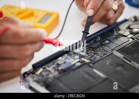Scheda madre, mani e scheda a circuito stampato con microchip, primo piano di progettazione e riparazione. Personale IT, hardware ed elettrico che lavora alla manutenzione Foto Stock