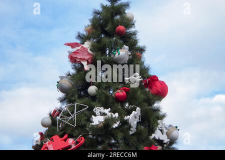 Un bellissimo albero di Natale è decorato con sacchi rossi e cervi sulla piazza Foto Stock