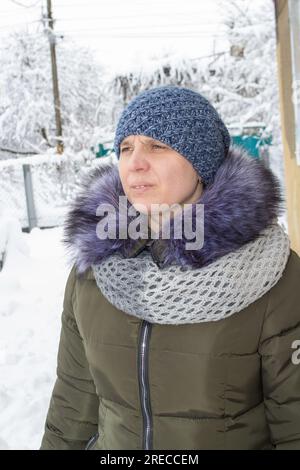 donna d'inverno in ritratto di neve, in strada della città europea. Natale e vacanze invernali. Nevicate. Foto Stock