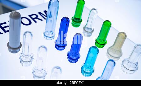 Preforme per bottiglie in plastica PET prima dello stampaggio a soffiaggio. Industria dell'imballaggio. Preforme PET dalla pressa per stampaggio a iniezione delle preforme. Materia prima per bottiglie in PET Foto Stock