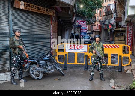 Le forze governative indiane sono in guardia mentre i musulmani sciiti del Kashmir prendono parte all'ottavo giorno della processione Muharram durante le commemorazioni dell'Ashura (decimo giorno di Muharram). In mezzo a una stretta sicurezza, dopo oltre trent'anni, le autorità indiane permisero all'ottava processione Muharram di passare attraverso la sua rotta tradizionale nella capitale del Kashmir, Srinagar. Ashura segna il martirio dell'Imam Hussain, nipote del Profeta Mohammed, e dei suoi familiari più stretti che furono uccisi nella battaglia di Karbala nell'Iraq meridionale nel 680. Foto Stock