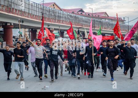 I musulmani sciiti del Kashmir piangono con bandiere religiose mentre prendono parte all'ottavo giorno della processione Muharram durante le commemorazioni dell'Ashura (decimo giorno di Muharram). In mezzo a una stretta sicurezza, dopo oltre trent'anni, le autorità indiane permisero all'ottava processione Muharram di passare attraverso la sua rotta tradizionale nella capitale del Kashmir, Srinagar. Ashura segna il martirio dell'Imam Hussain, nipote del Profeta Mohammed, e dei suoi familiari più stretti che furono uccisi nella battaglia di Karbala nell'Iraq meridionale nel 680. Foto Stock