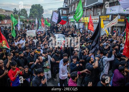 I musulmani sciiti del Kashmir piangono con bandiere religiose mentre prendono parte all'ottavo giorno della processione Muharram durante le commemorazioni dell'Ashura (decimo giorno di Muharram). In mezzo a una stretta sicurezza, dopo oltre trent'anni, le autorità indiane permisero all'ottava processione Muharram di passare attraverso la sua rotta tradizionale nella capitale del Kashmir, Srinagar. Ashura segna il martirio dell'Imam Hussain, nipote del Profeta Mohammed, e dei suoi familiari più stretti che furono uccisi nella battaglia di Karbala nell'Iraq meridionale nel 680. Foto Stock