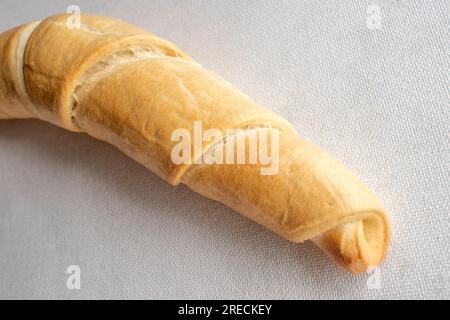 Pane salato: Una foto ravvicinata del delizioso pane croccante con un condimento salato viene visualizzata su una superficie bianca pulita. Perfetto per uno spuntino Foto Stock