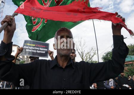 27 luglio 2023, Srinagar, Jammu e Kashmir, India: Un musulmano sciita del Kashmir ha visto tenere una bandiera religiosa mentre prende parte a una processione Muharram l'ottavo giorno di Muharram a Srinagar, dopo che il governo statale ha permesso la processione Muharram Alam attraverso il suo percorso tradizionale a Srinagar da Gurubazar a Dalgate. (Immagine di credito: © Adil Abbas/ZUMA Press Wire) SOLO USO EDITORIALE! Non per USO commerciale! Foto Stock